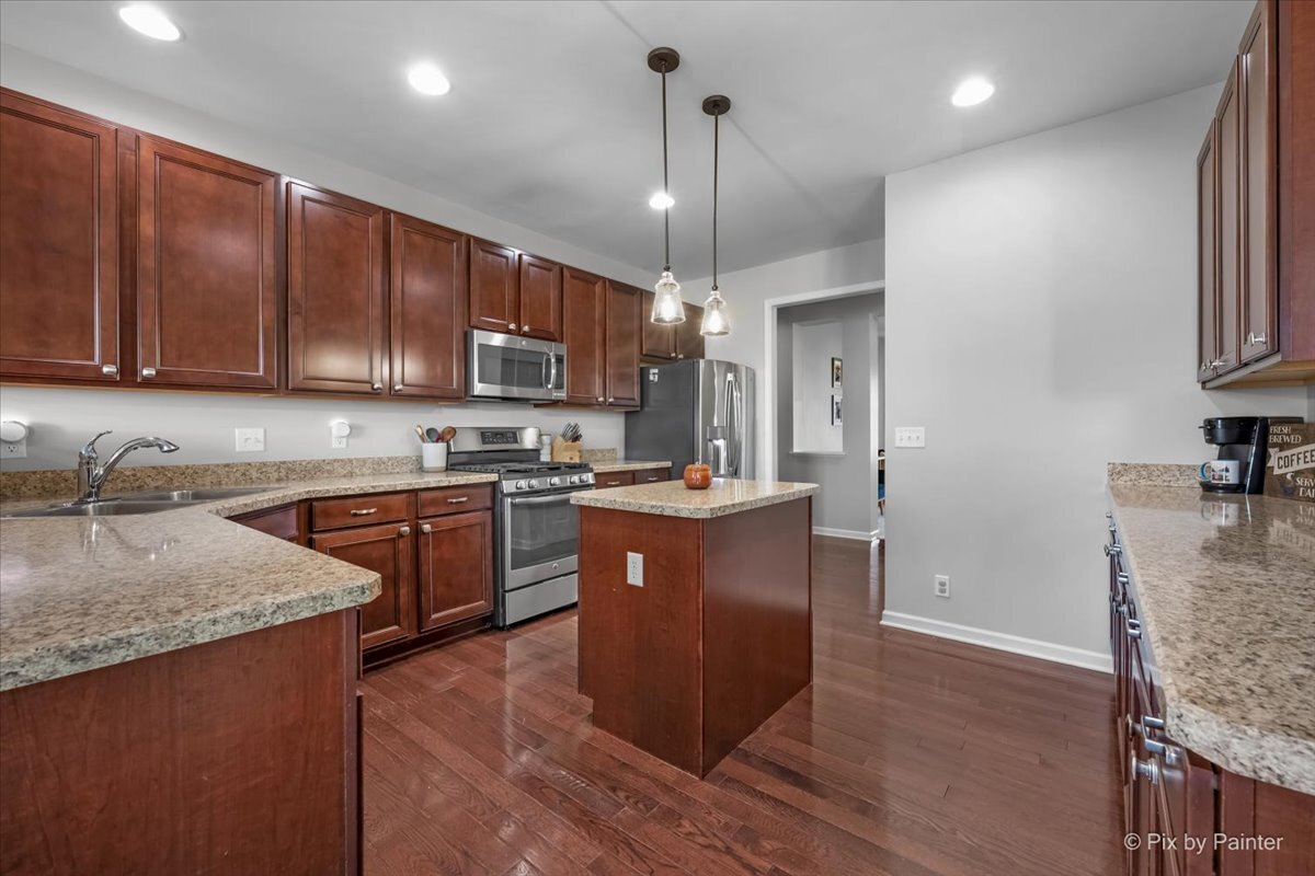 691 Windett Ridge Road Yorkville, IL 60560 - Photo 10 of 42 a kitchen with stainless steel appliances granite countertop wooden cabinets a refrigerator and a sink