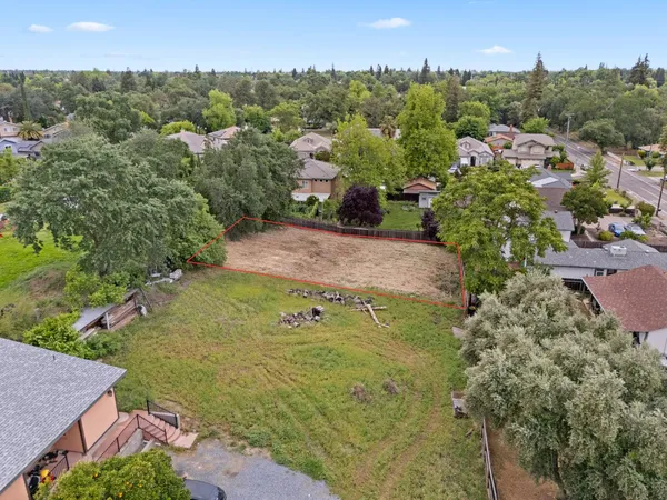 an aerial view of residential houses with outdoor space and trees