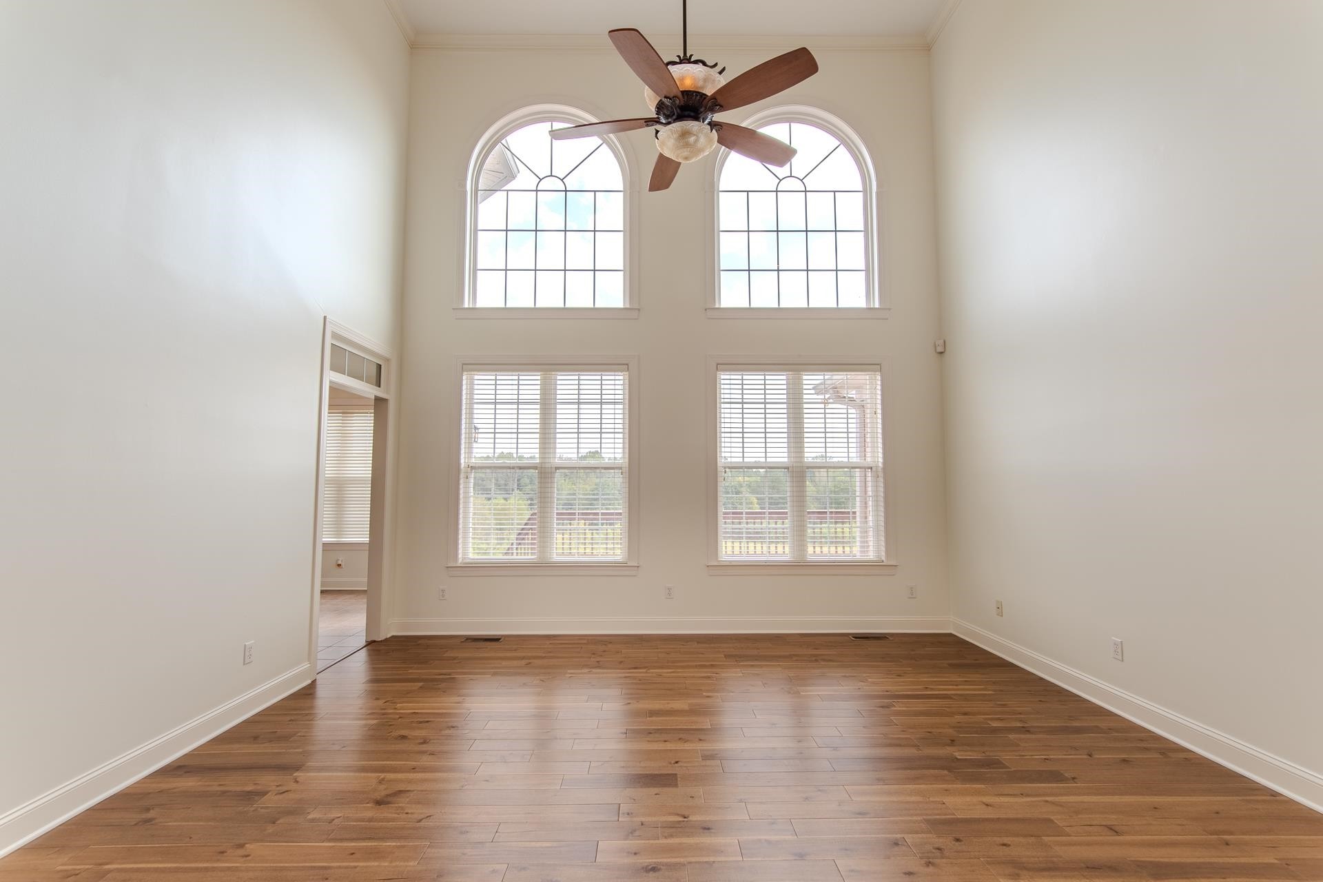 5166 Middlefork Road Luray, TN 38352 - Photo 7 of 40 an empty room with wooden floor fan and windows