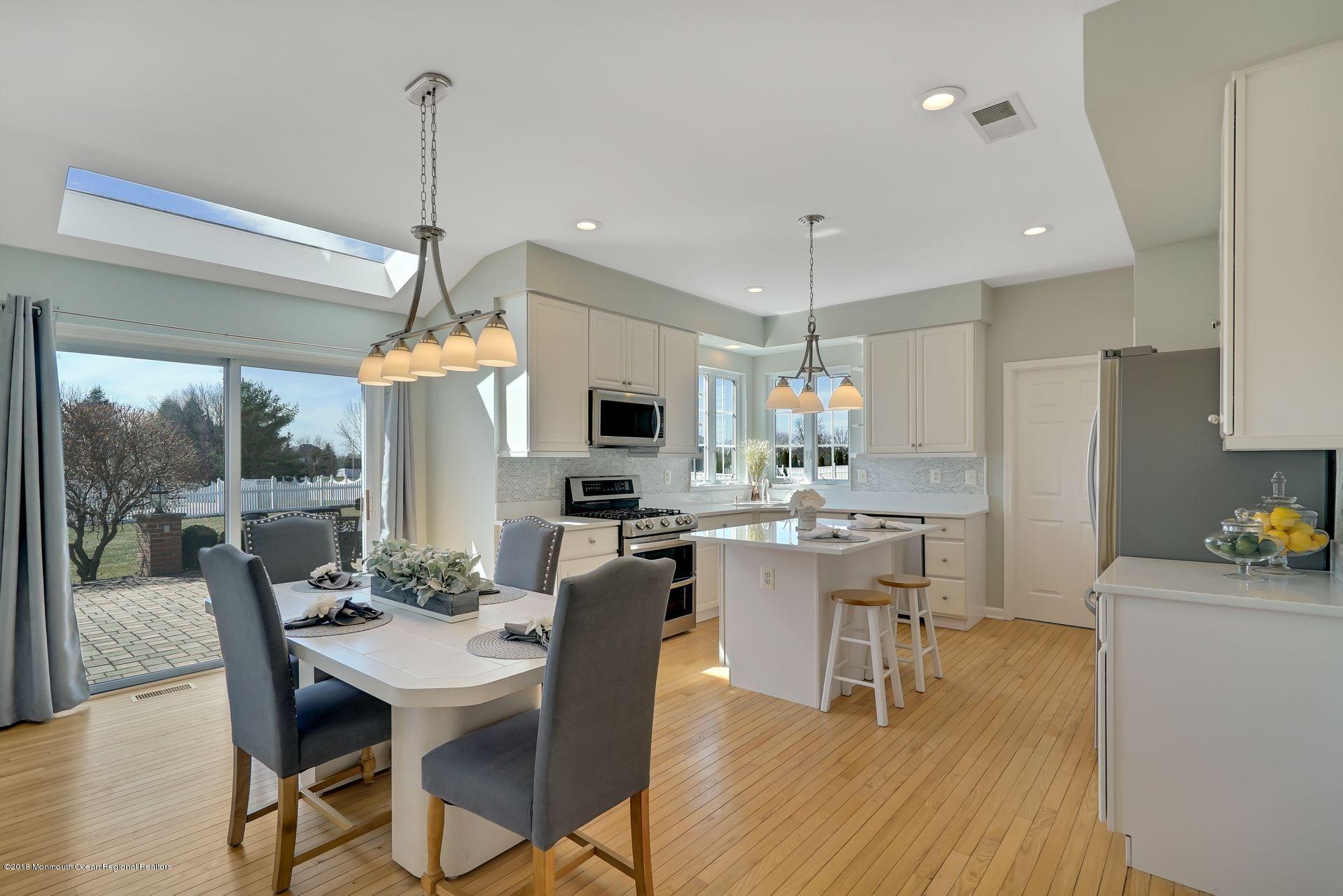 263 Pin Oak Road Freehold, NJ 07728 - Photo 19 of 60 a view of a dining room and livingroom with furniture wooden floor a chandelier