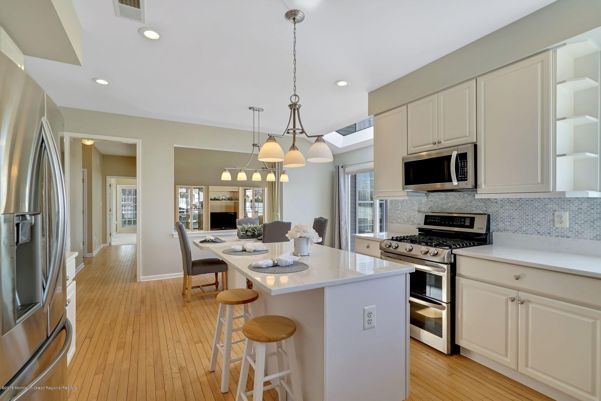 263 Pin Oak Road Freehold, NJ 07728 - Photo 24 of 60 a open kitchen with stainless steel appliances granite countertop a stove top oven a sink dishwasher a dining table and chairs with wooden floor