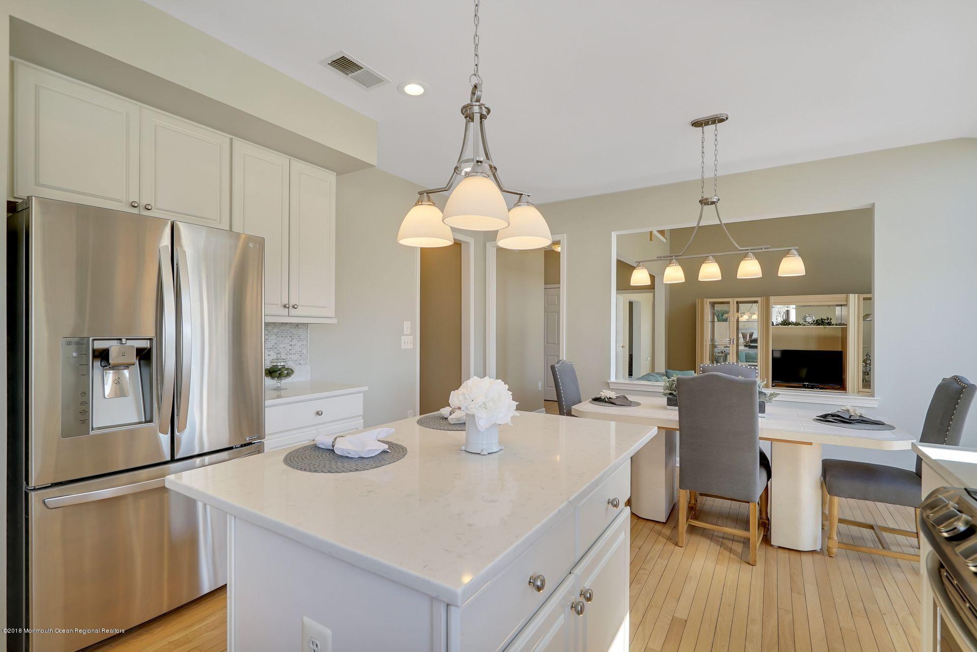 263 Pin Oak Road Freehold, NJ 07728 - Photo 25 of 60 a kitchen with stainless steel appliances a dining table chairs and wooden floor