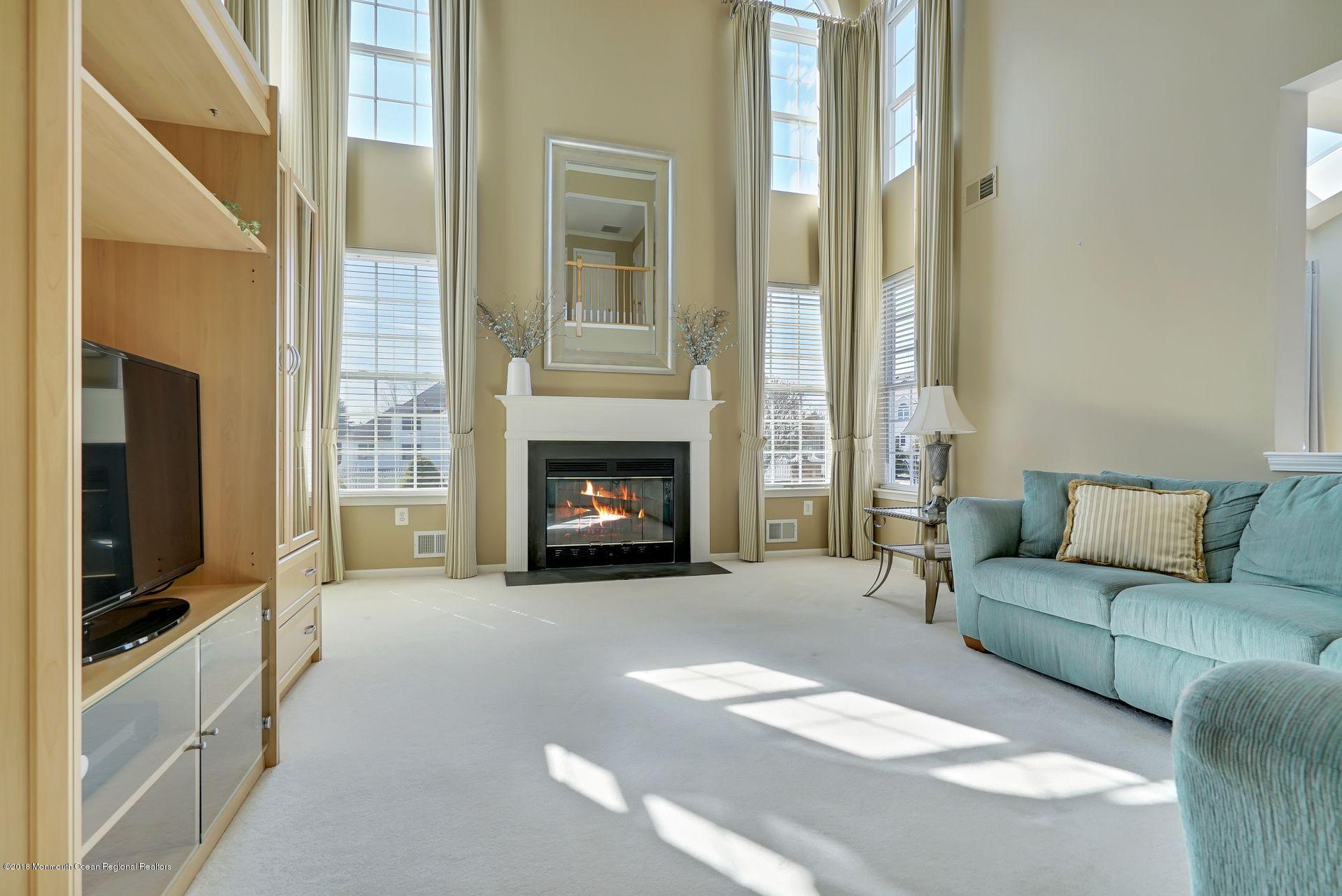 263 Pin Oak Road Freehold, NJ 07728 - Photo 27 of 60 a living room with furniture a flat screen tv and a fireplace