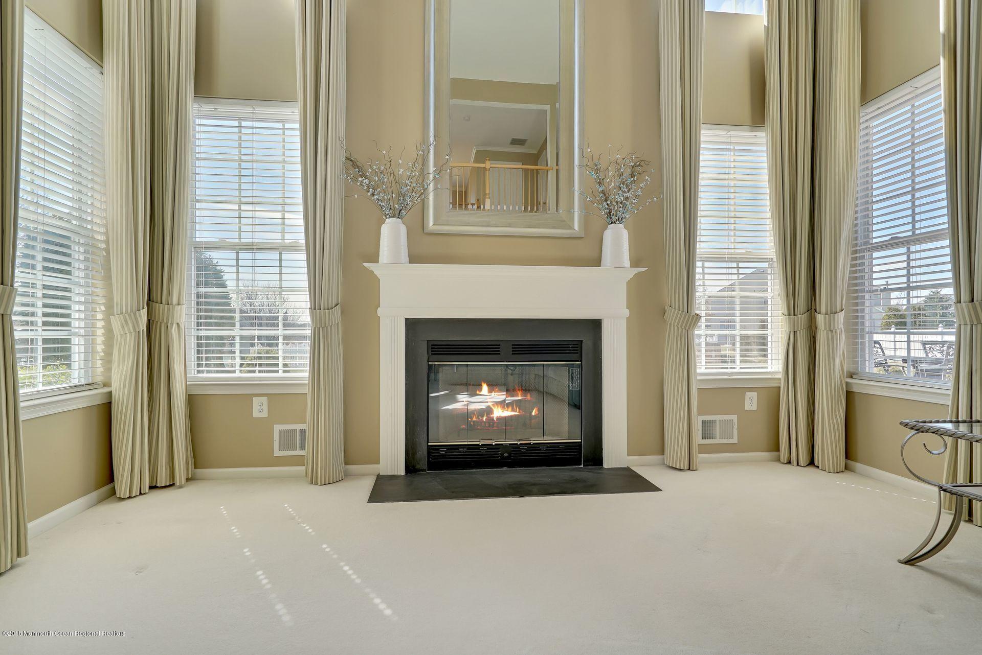 263 Pin Oak Road Freehold, NJ 07728 - Photo 29 of 60 a living room with a fireplace and a large window