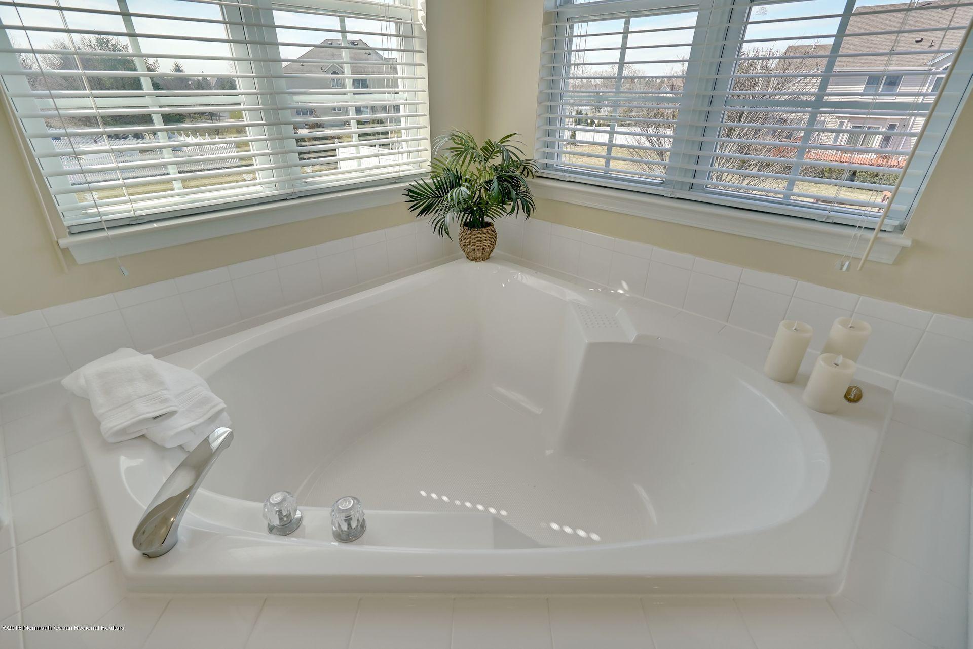 263 Pin Oak Road Freehold, NJ 07728 - Photo 45 of 60 a white bath tub sitting next to a window