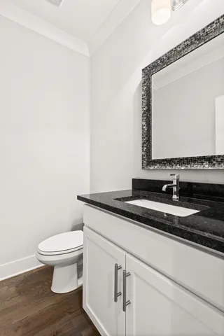 a bathroom with a granite countertop toilet sink and mirror