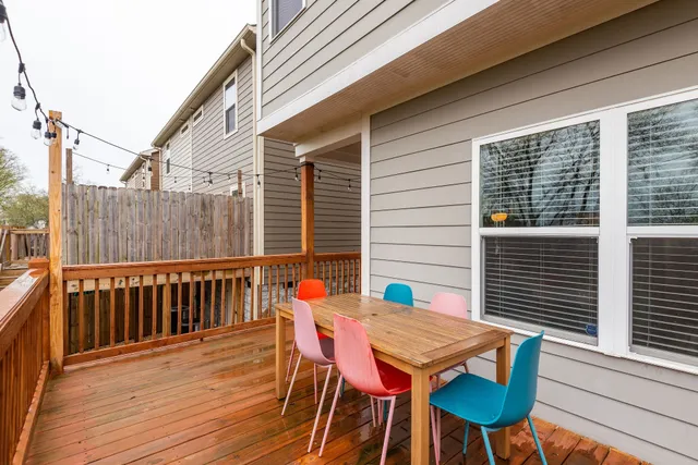 a view of a backyard with a wooden fence and large trees