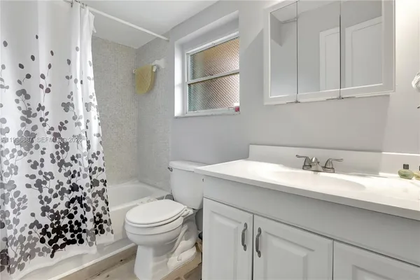 a bathroom with a granite countertop sink toilet and mirror