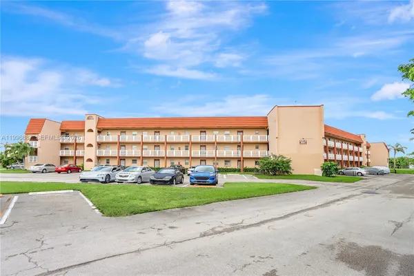 a view of a tall buildings with a big yard and large trees