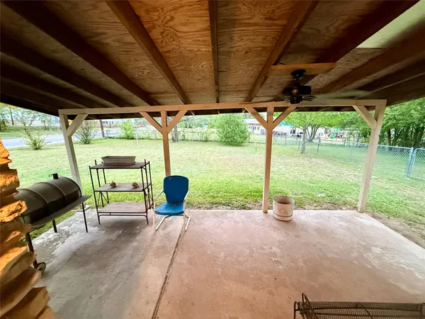 a view of backyard with table and chairs and potted plants