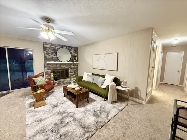 a living room with furniture a fireplace and a window