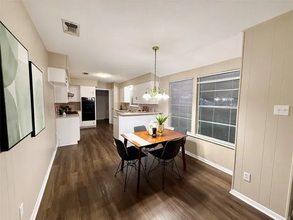 a dining room with furniture a chandelier and wooden floor
