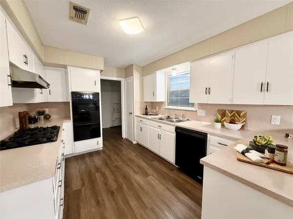 a kitchen with a sink stove top oven and cabinets