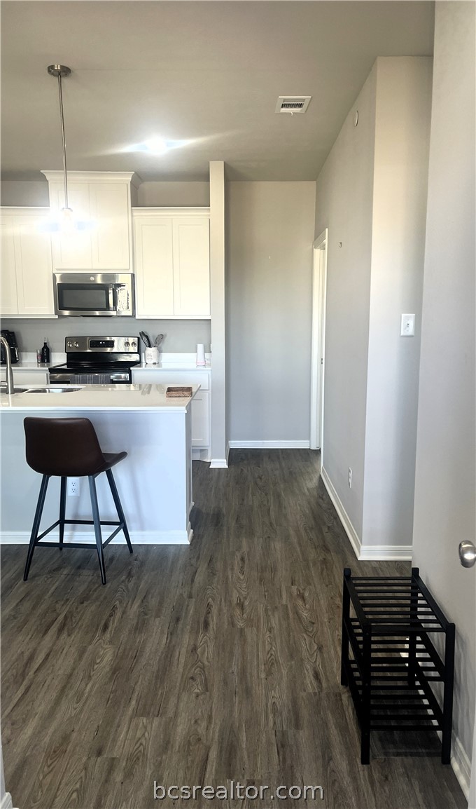 1326 Prairie Drive, Unit 1021 Bryan, TX 77803 - Photo 3 of 17 a kitchen with wooden floors and chairs