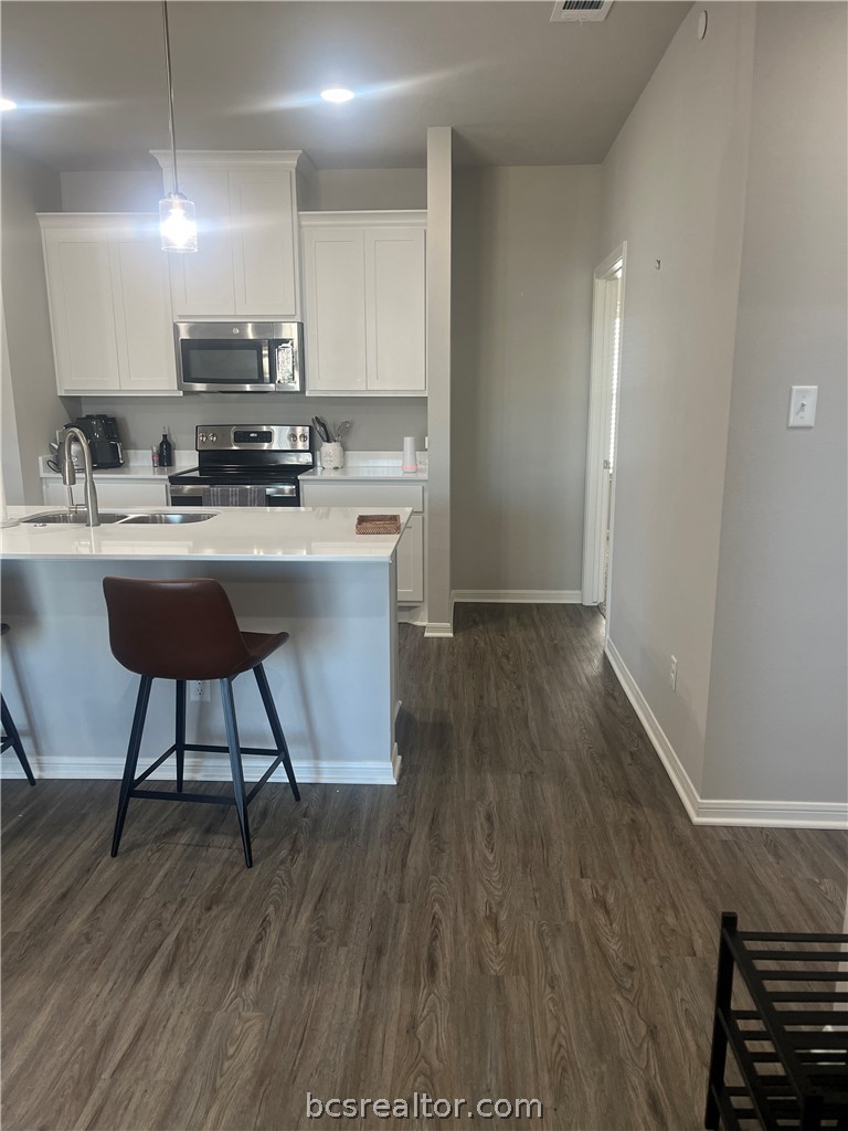 1326 Prairie Drive, Unit 1021 Bryan, TX 77803 - Photo 4 of 17 a kitchen with stainless steel appliances a sink a stove a refrigerator and cabinets
