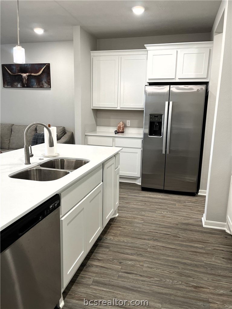 1326 Prairie Drive, Unit 1021 Bryan, TX 77803 - Photo 6 of 17 a kitchen with stainless steel appliances granite countertop a sink a refrigerator a microwave a sink and white cabinets