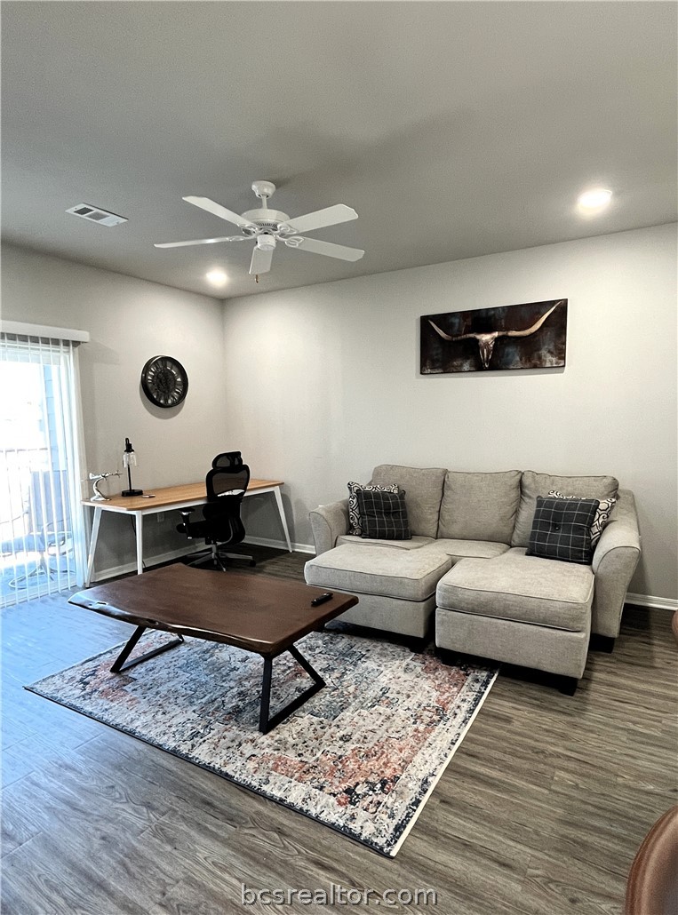1326 Prairie Drive, Unit 1021 Bryan, TX 77803 - Photo 8 of 17 a living room with couches a coffee table and projector with wooden floor