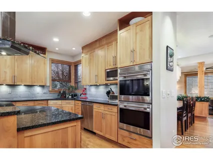 a kitchen with stainless steel appliances granite countertop a sink a stove and cabinets