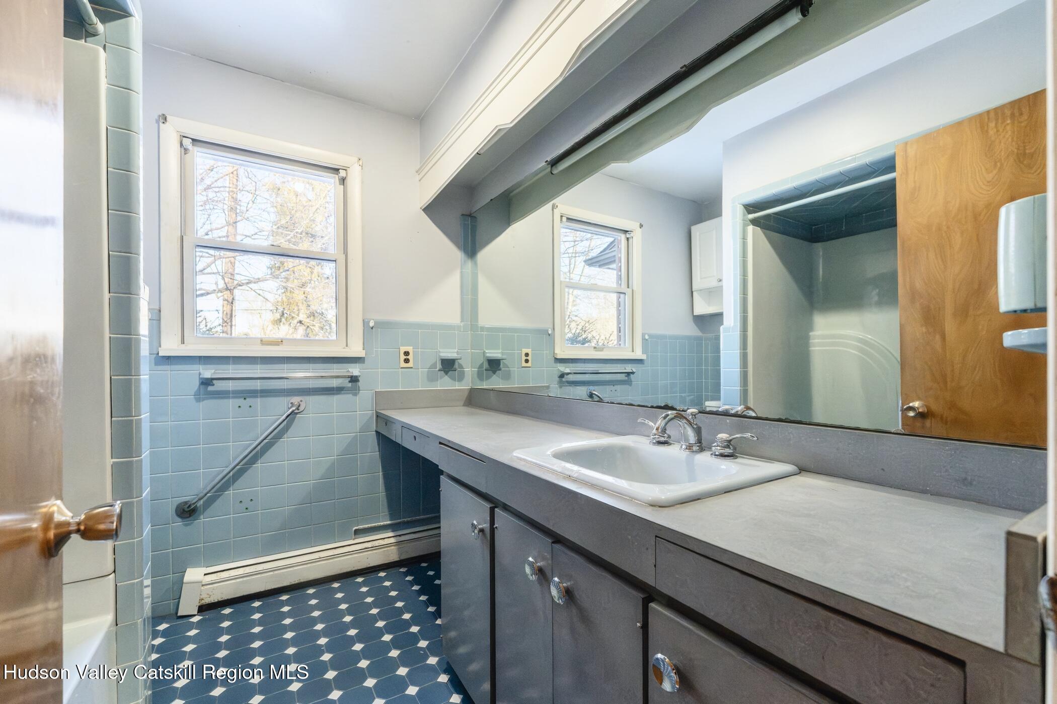 609 New Paltz Road Highland, NY 12528 - Photo 16 of 35 a bathroom with a granite countertop sink a mirror and a bathtub