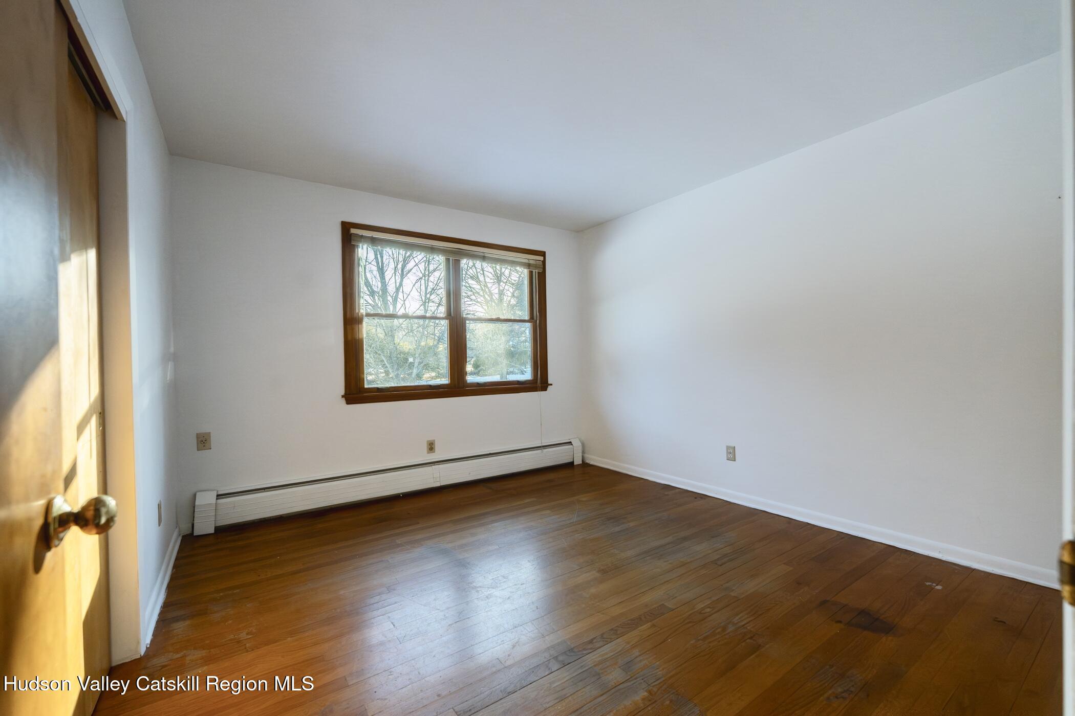 609 New Paltz Road Highland, NY 12528 - Photo 19 of 35 an empty room with wooden floor and windows