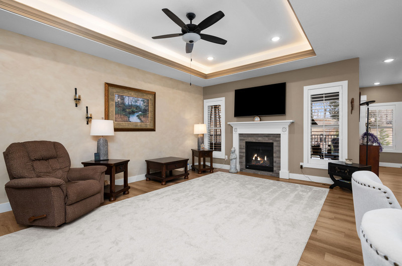 4418 Chestnut Drive Bettendorf, IA 52722 - Photo 13 of 45 a living room with furniture a flat screen tv and a fireplace