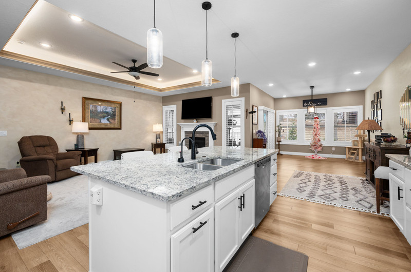4418 Chestnut Drive Bettendorf, IA 52722 - Photo 14 of 45 a large kitchen with kitchen island a stove a sink a dining table and chairs with wooden floor