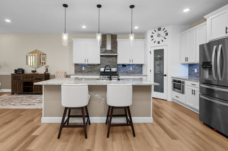 4418 Chestnut Drive Bettendorf, IA 52722 - Photo 16 of 45 a kitchen with stainless steel appliances a dining table chairs refrigerator and sink