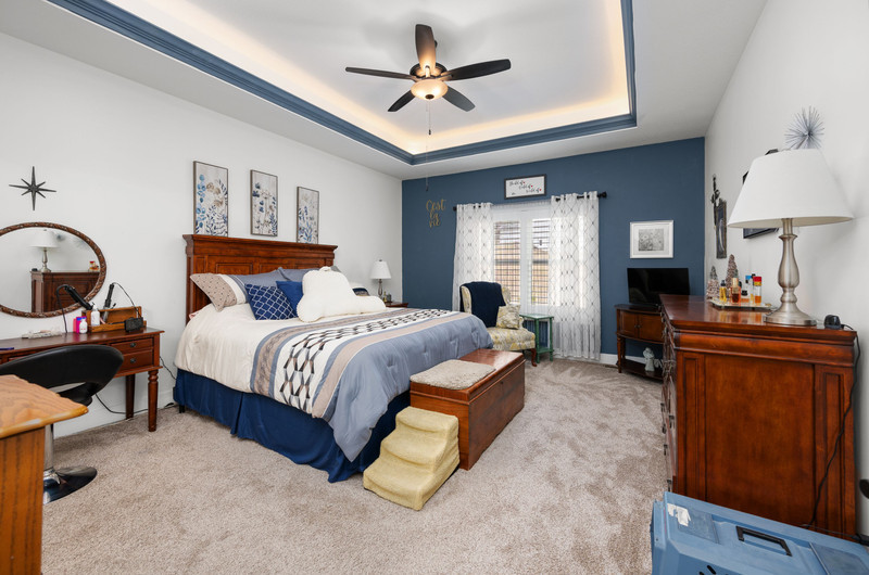 4418 Chestnut Drive Bettendorf, IA 52722 - Photo 23 of 45 a spacious bedroom with a bed a dresser and potted plant
