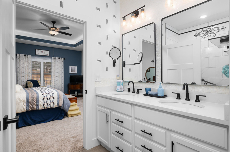 4418 Chestnut Drive Bettendorf, IA 52722 - Photo 28 of 45 a en suite bathroom with a double vanity sink a mirror a glass door a shower and a mirror