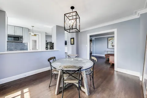 a view of a dining room with furniture wooden floor and a chandelier