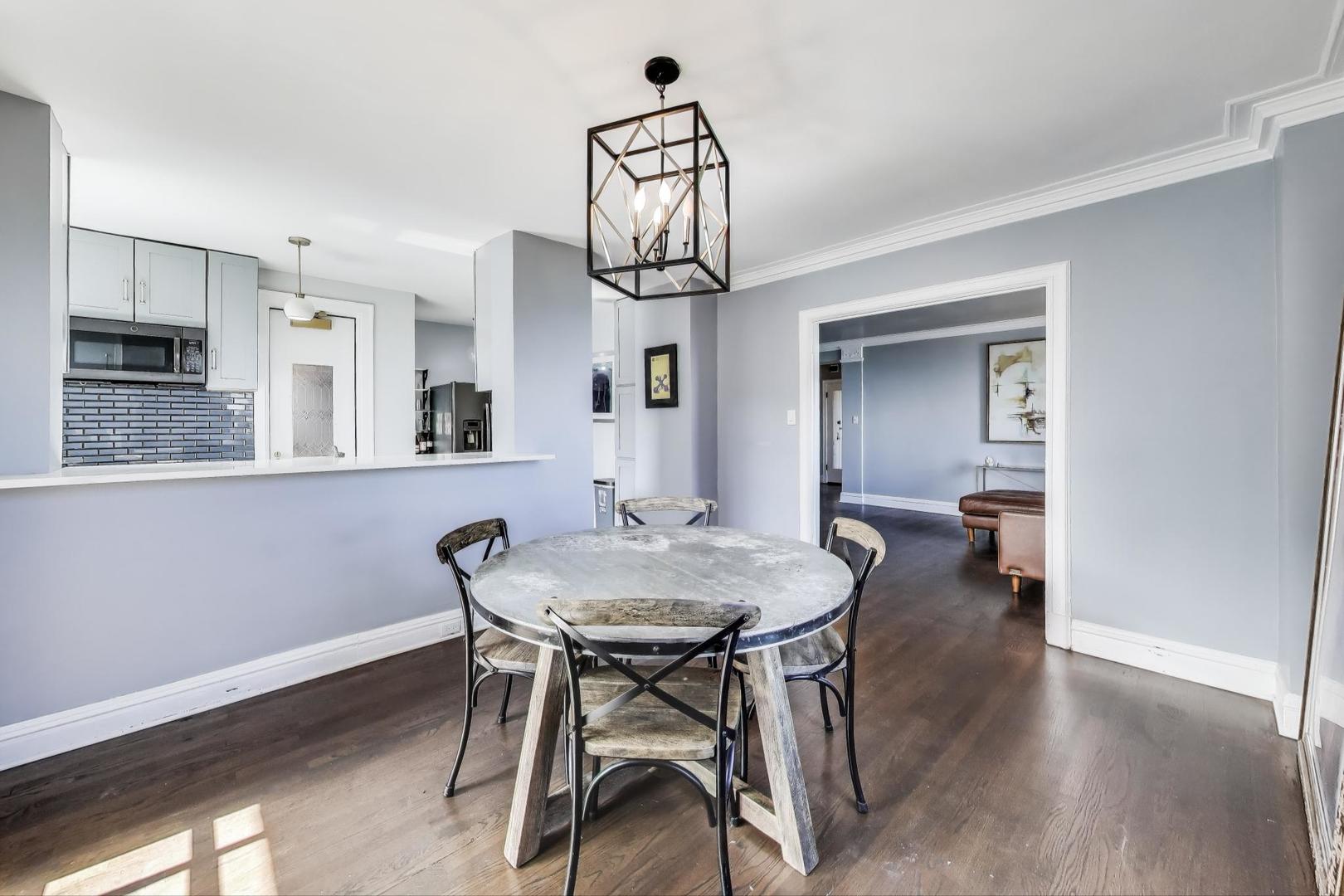 1765 East 55th Street, Unit J2 Chicago, IL 60637 - Photo 11 of 21 a view of a dining room with furniture wooden floor and a chandelier