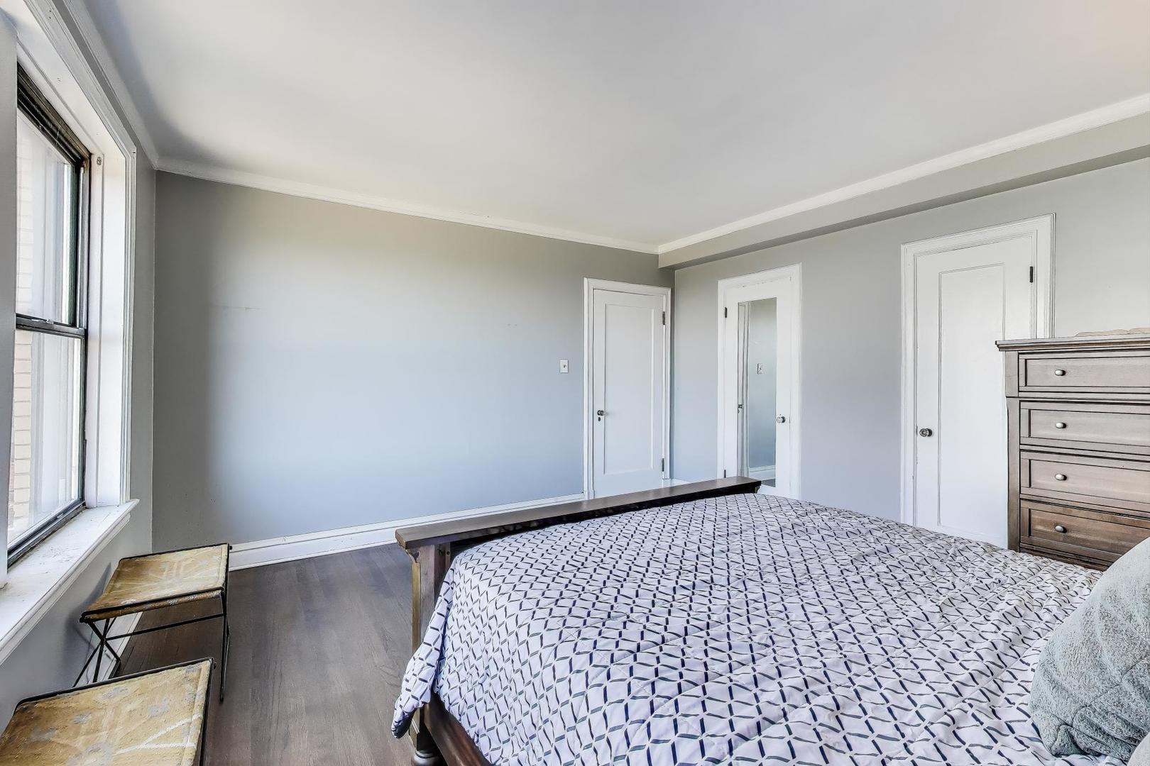 1765 East 55th Street, Unit J2 Chicago, IL 60637 - Photo 16 of 21 a bedroom with a bed and wooden floor