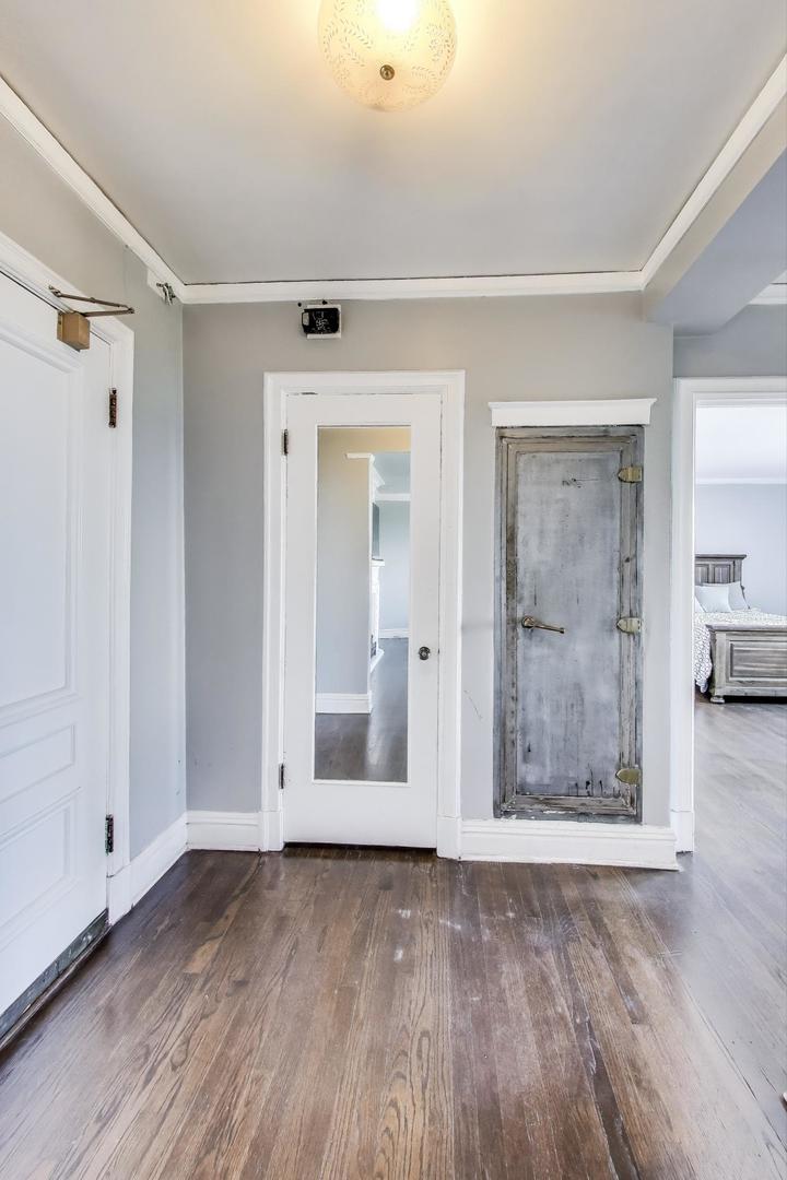 1765 East 55th Street, Unit J2 Chicago, IL 60637 - Photo 4 of 21 a view of a hallway with wooden floor and a bathroom