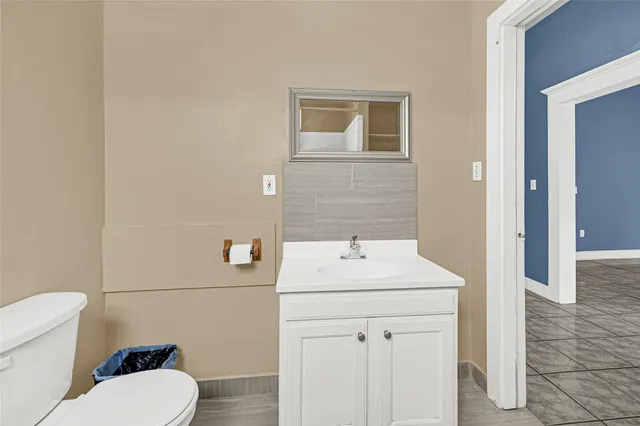 a bathroom with a sink toilet and mirror