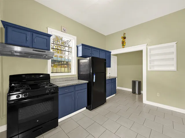 a kitchen with stainless steel appliances granite countertop a refrigerator and a stove top oven