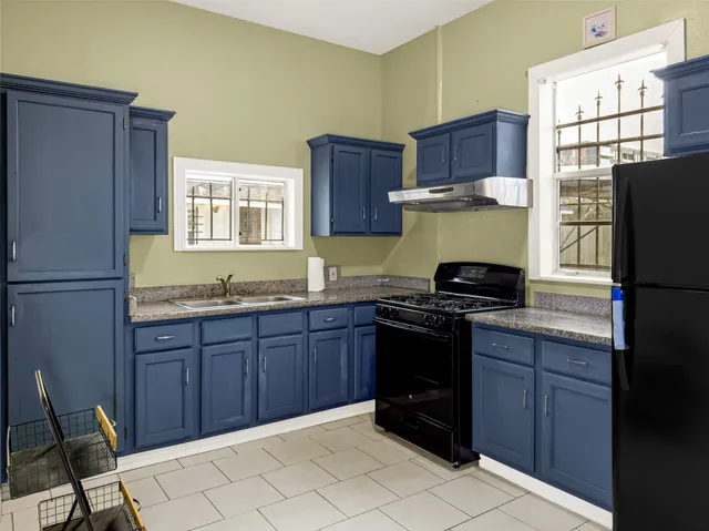 a kitchen with granite countertop wooden cabinets and a stove top oven