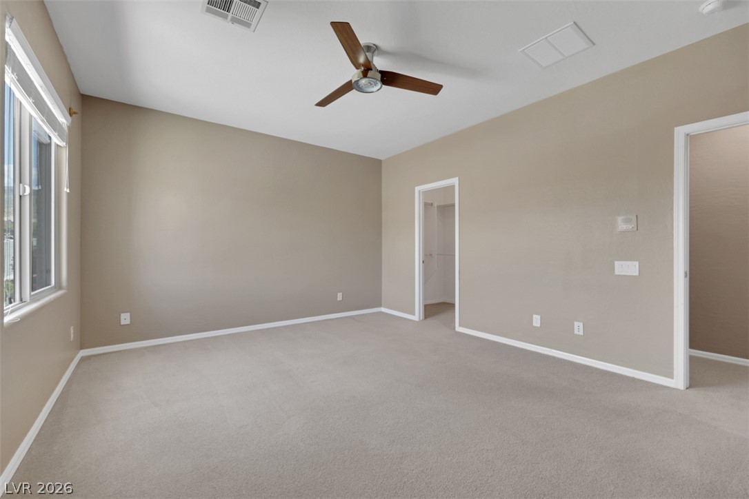 2501 Bechamel Place Henderson, NV 89044 - Photo 33 of 50 A spacious bedroom offers comfort with plush carpeting and a large window.
