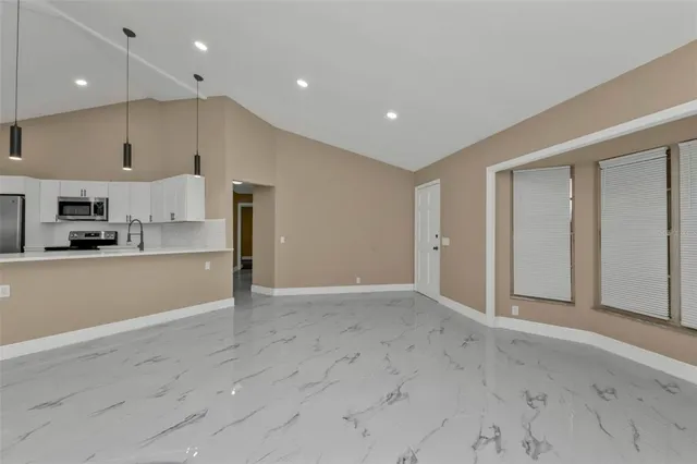 a view of a big room with kitchen and windows