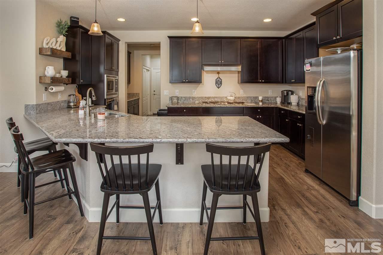 2940 Tobiano Drive Reno, NV 89521 - Photo 5 of 29 a kitchen with stainless steel appliances granite countertop a kitchen island a table and chairs