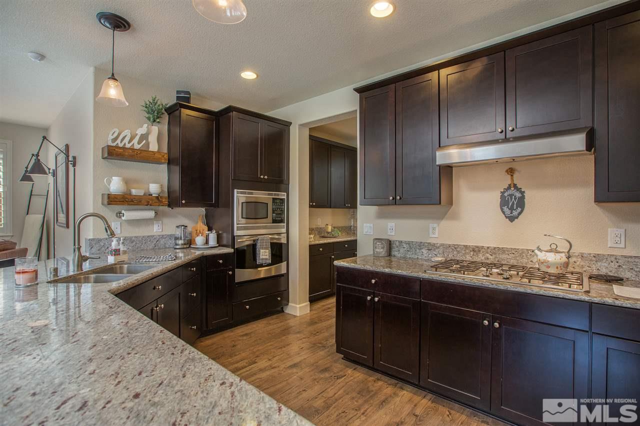 2940 Tobiano Drive Reno, NV 89521 - Photo 6 of 29 a large kitchen with kitchen island granite countertop a sink stainless steel appliances and cabinets
