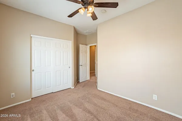 a view of an empty room and chandelier fan