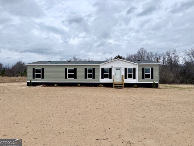 a front view of house with yard and trees around