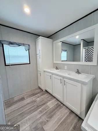 a spacious bathroom with a double vanity sink and a mirror