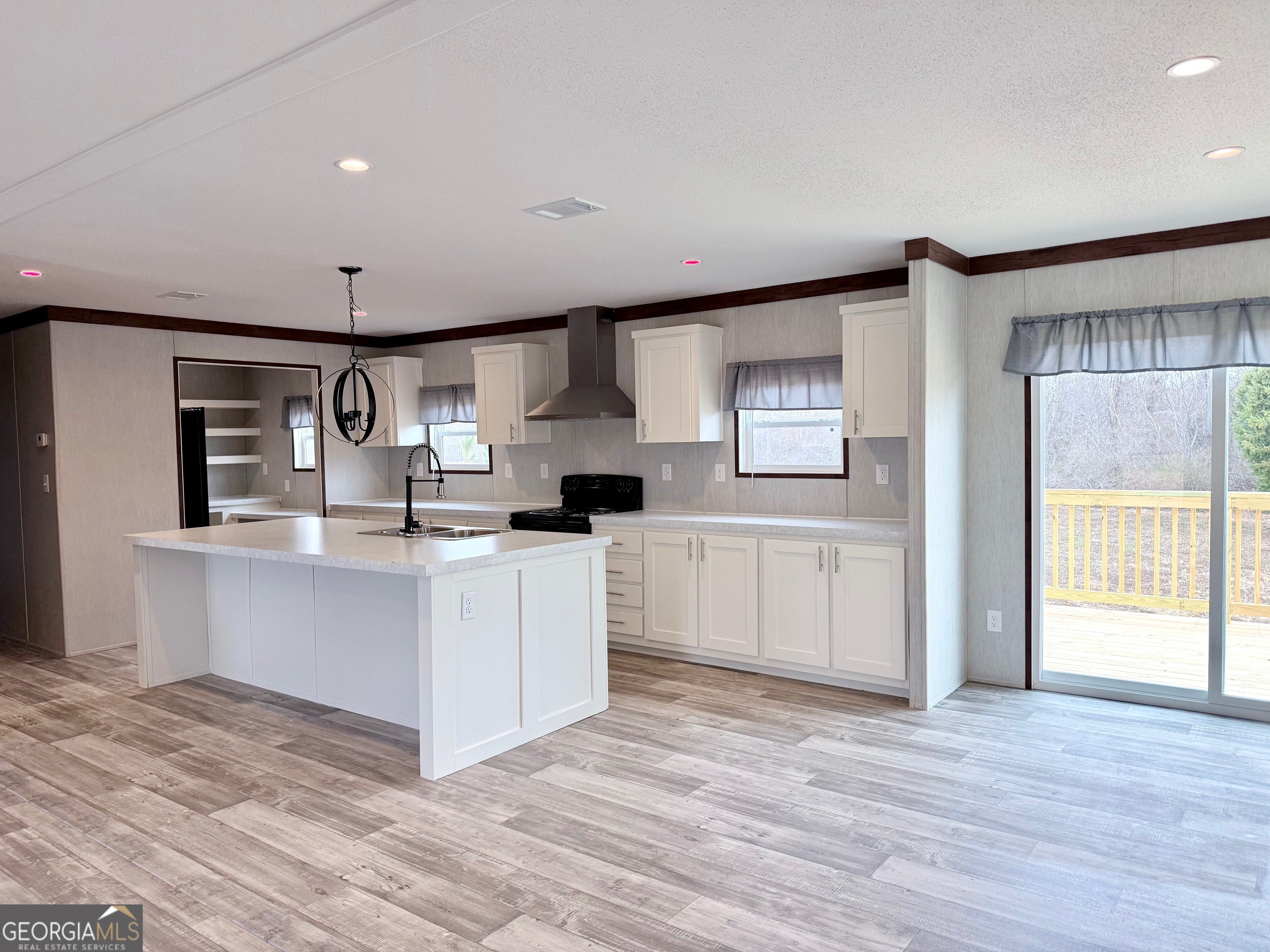 683 Evergreen Church Road Cobbtown, GA 30420 - Photo 3 of 32 a kitchen with stainless steel appliances white cabinets and wooden floor