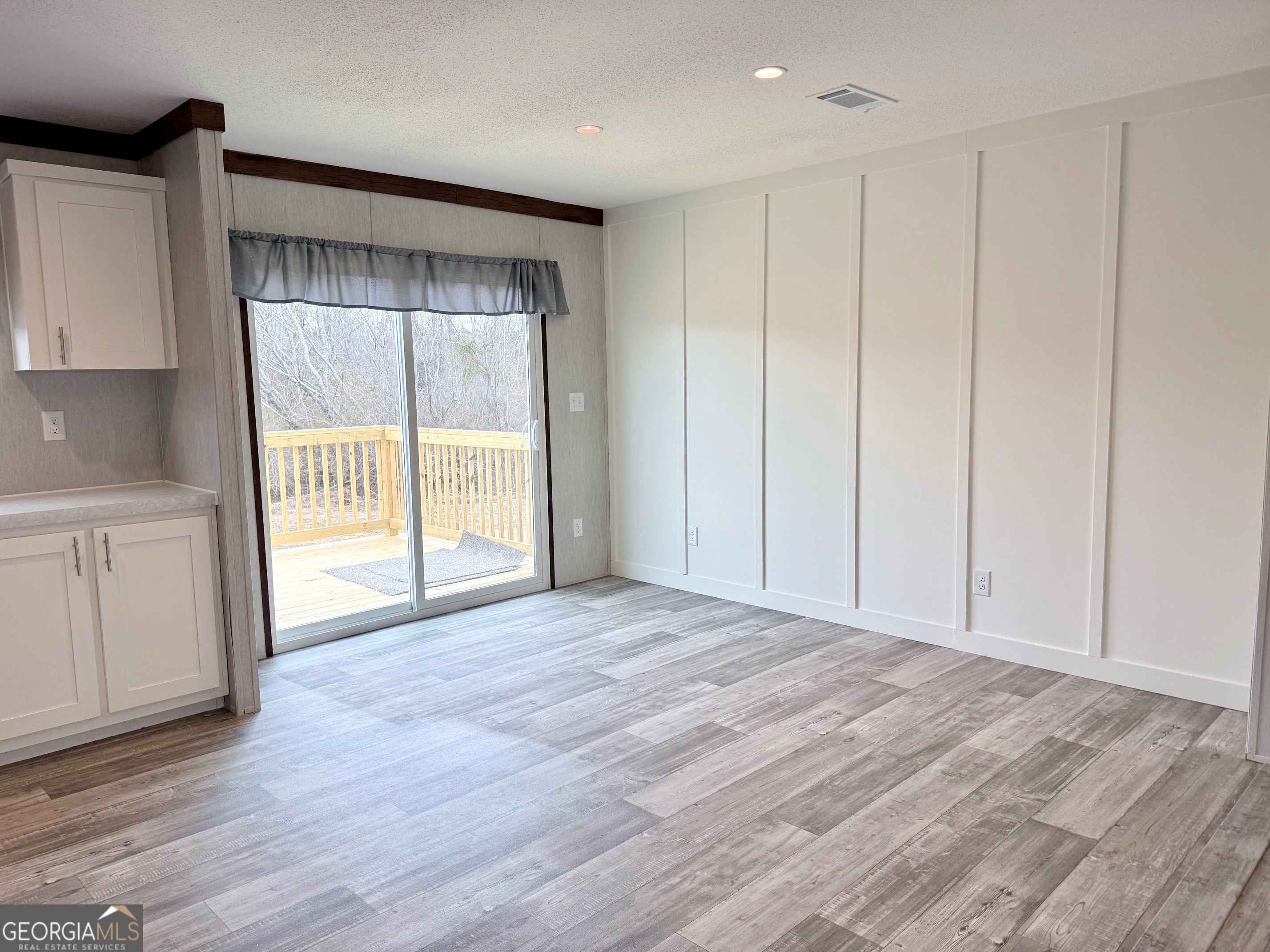 683 Evergreen Church Road Cobbtown, GA 30420 - Photo 6 of 32 a view of an empty room with wooden floor and a cabinet