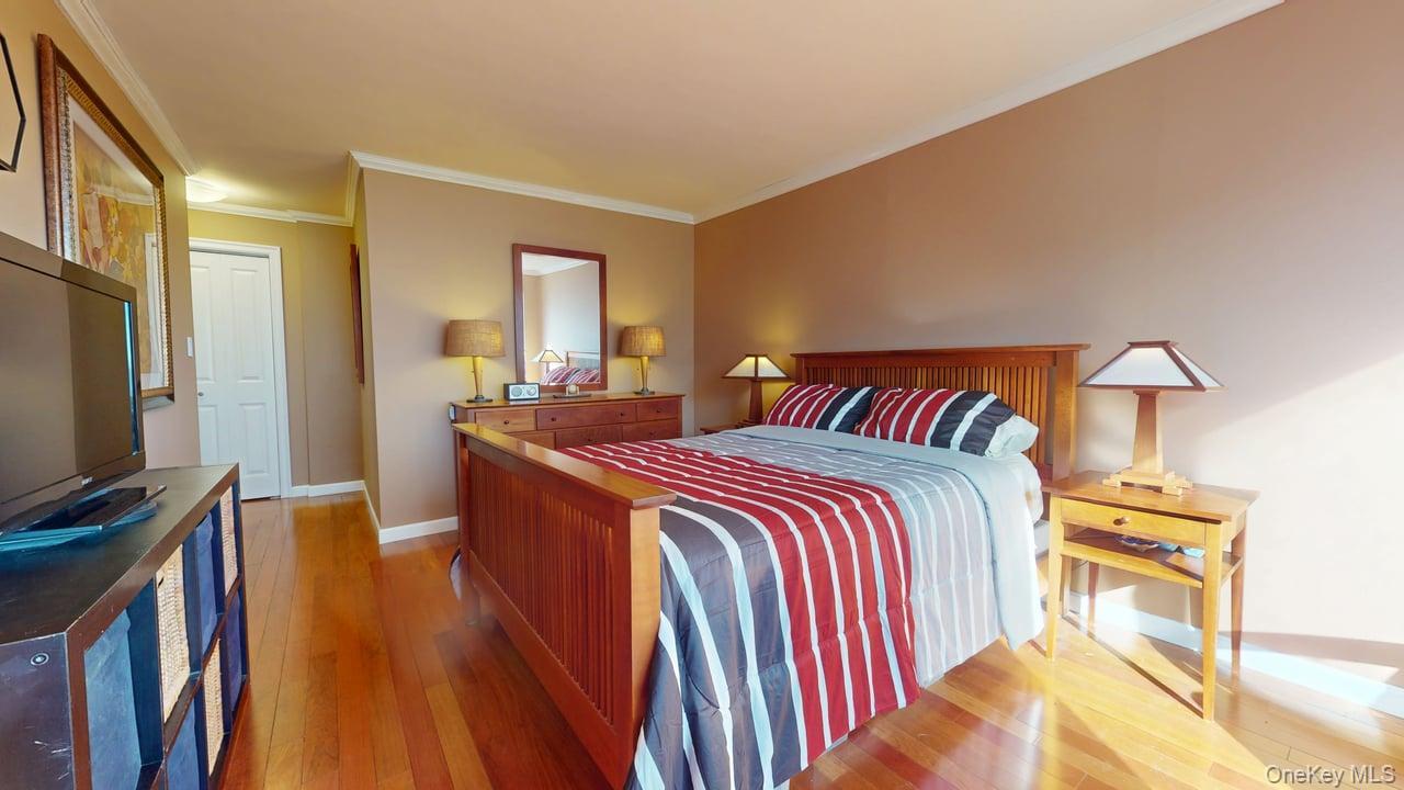 118-17 Union Turnpike, Unit 5H Queens, NY 11375 - Photo 11 of 48 a bedroom with a bed and wooden floor