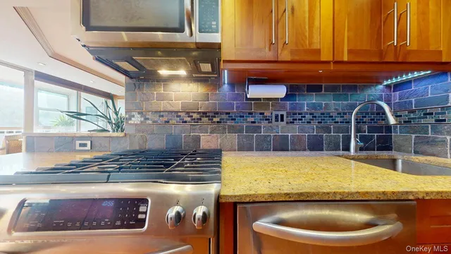 a kitchen with stainless steel appliances granite countertop a sink and a white cabinets
