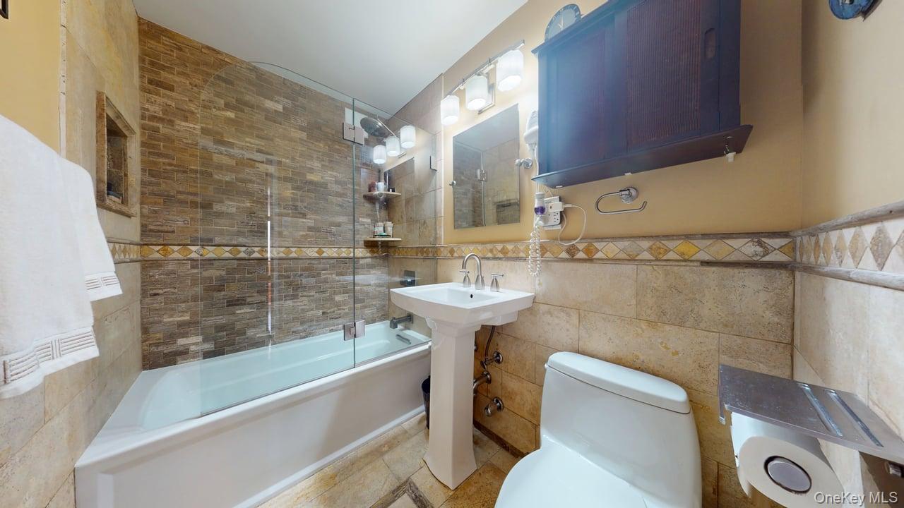 118-17 Union Turnpike, Unit 5H Queens, NY 11375 - Photo 30 of 48 a bathroom with a sink and a bathtub