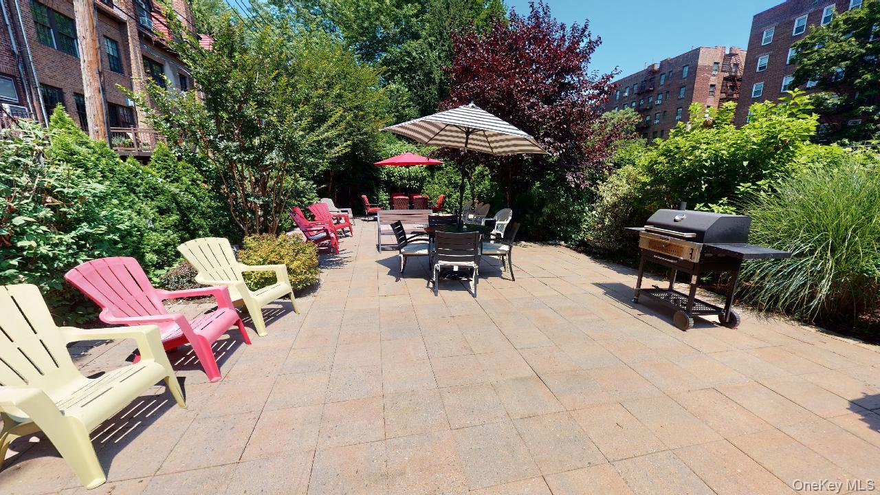 118-17 Union Turnpike, Unit 5H Queens, NY 11375 - Photo 45 of 48 a view of a tables and chairs under an umbrella in the patio