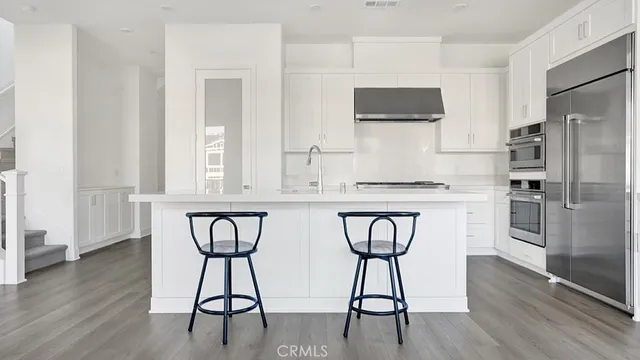 a kitchen with stainless steel appliances a refrigerator and microwave